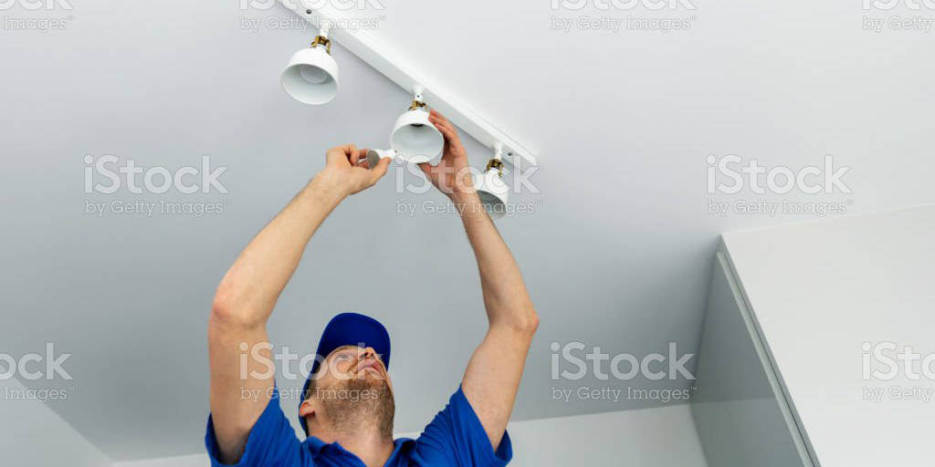 electrician installing led light bulbs in ceiling lamp